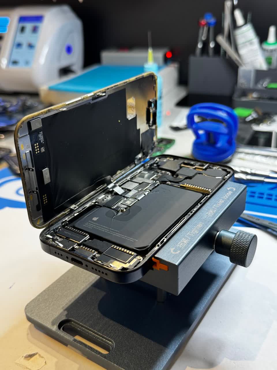 Tehnician Profix Mobile reparând un telefon la bancul de lucru